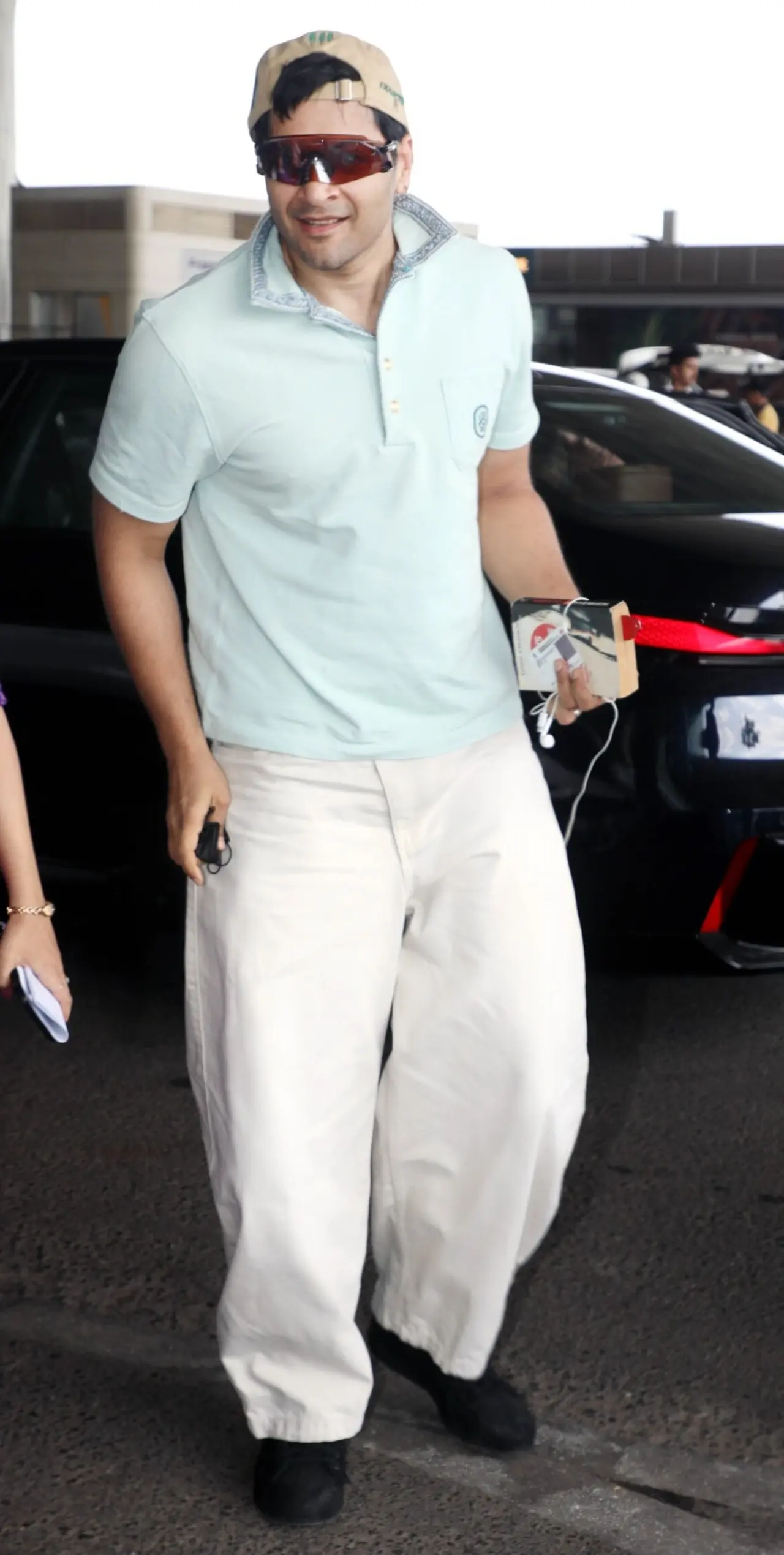 Ali Fazal kept his airport look sporty and relaxed in a pastel blue polo T-shirt paired with loose beige trousers. He layered the casual outfit with a cap.